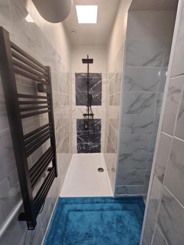 La salle de bains est pourvue d'une douche et d'une baignoire bleue. dans l'établissement Au BleuRivage, à Ensuès-la-Redonne