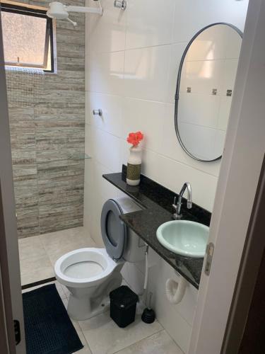 uma casa de banho com um WC, um lavatório e um espelho. em Apto Amar - No Espaço Florescer em Campos dos Goytacazes