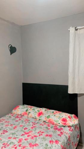 a bedroom with a bed with a floral comforter at Apê da VAN acomoda até 7 pessoas in Garanhuns