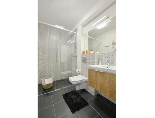 ein weißes Badezimmer mit Waschbecken und Toilette in der Unterkunft Apartamenty Płomnica in Karpacz