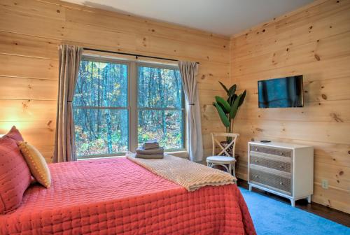 een slaapkamer met een bed en een groot raam bij Baby Bear: Peaceful cabin on Bearwallow Mountain with hot tub and close to hiking! in Hendersonville