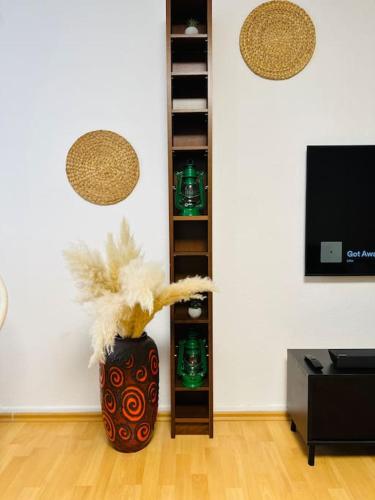 a vase with feathers in a room with a tv at Mülheim an der Ruhr innenstadt in Mülheim an der Ruhr