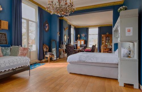 1 dormitorio con paredes azules, 1 cama y lámpara de araña en Villa Dalenstein, en Velp