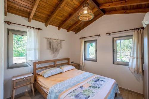 a bedroom with a bed in a room with windows at Stone Mini House Datça in Datca
