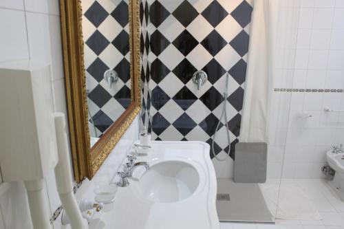 a bathroom with a toilet and a mirror at La Maison Dorée in Giardini Naxos