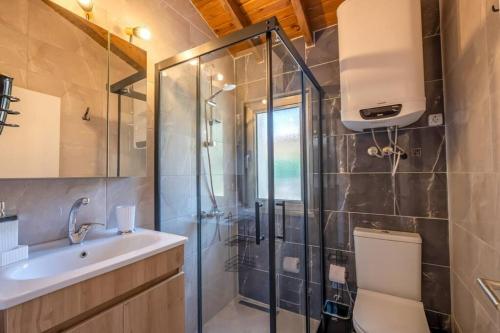 a bathroom with a shower and a toilet and a sink at Stone Mini House Datça in Datca