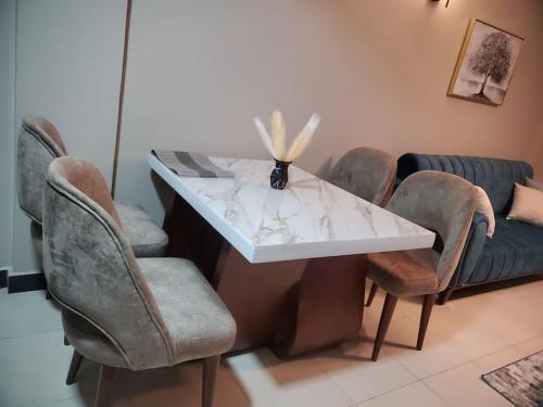 mesa con sillas y encimera de mármol blanco en Cozy apartment in heart of Kampala en Kira