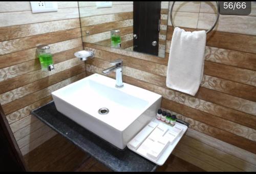 a bathroom with a white sink and a mirror at HOTEL MARIYA INTERNATIONAL in Bodh Gaya