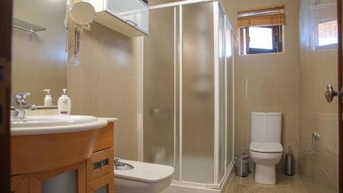 a bathroom with a shower and a toilet and a sink at Casa do Avô Machado in Abrantes