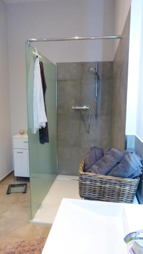 ein Bad mit einer Dusche und einem Korb mit Handtüchern in der Unterkunft City Studio Kormoran in Bremerhaven