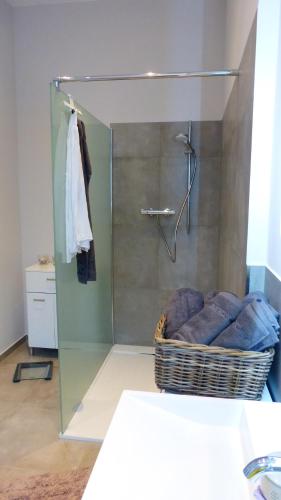 a bathroom with a shower with a basket of towels at City Studio Kormoran in Bremerhaven
