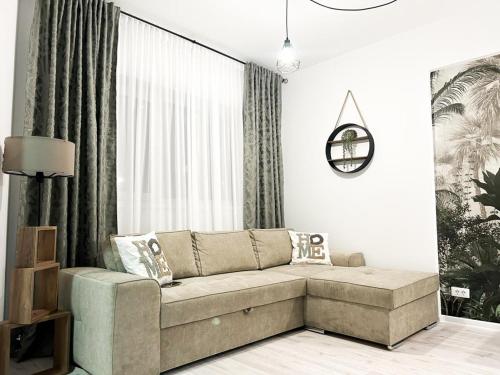 - un salon avec un canapé en face d'une fenêtre dans l'établissement Eucalyptus Apartament, à Braşov