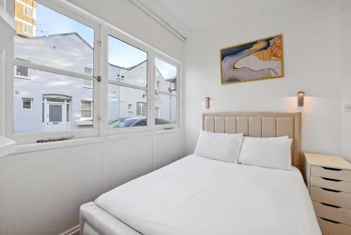 a bedroom with a bed and a window at The Mews Apartment In Kensington in London