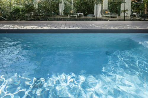 une grande piscine d'eau bleue dans une cour dans l'établissement GROUND FLOOR VILLA GRAZIELLA 200 M FROM THE BEACH, à Èze