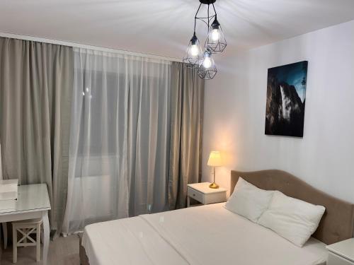 a bedroom with a bed and a desk and a window at Premium HILS Pallady in Bucharest
