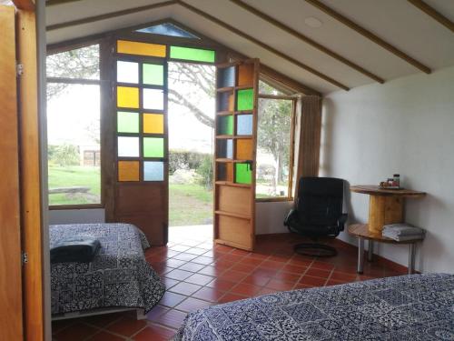 a room with two beds and a door with stained glass at CABAÑA LOS JUANES in Sutamarchán