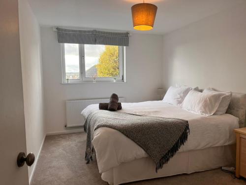 a teddy bear sitting on a bed in a bedroom at Cosy flat in the Heart of Wandsworth in London