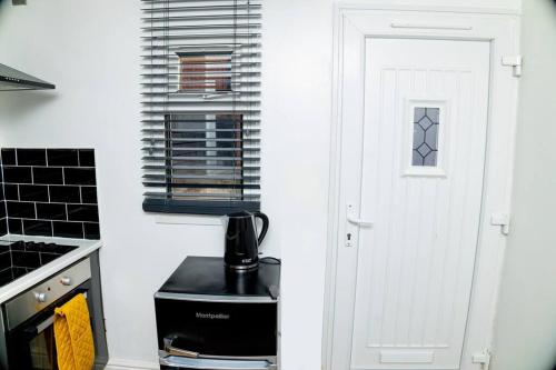 曼徹斯特的住宿－Cosy Manchester Haven for Two，厨房的白色门,配有咖啡壶