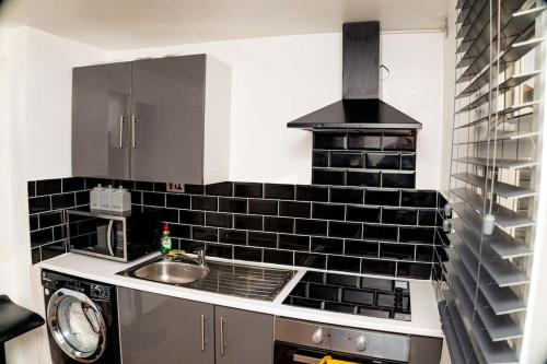 a kitchen with a sink and a stove at Cosy Manchester Haven for Two in Manchester