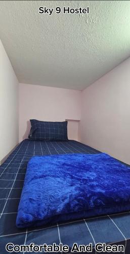 a bedroom with a blue blanket on a bed at SKY 9 Hostel ,UNION METRO in Dubai