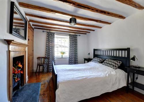 a bedroom with a large bed and a fireplace at The Crown in Dolgellau