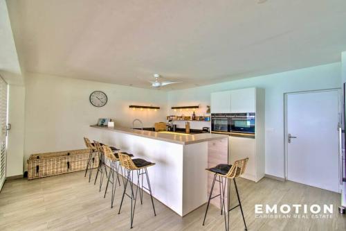 a kitchen with a counter and stools in a room at Appartement 2 chambres sur la plage de grand case in Grand Case