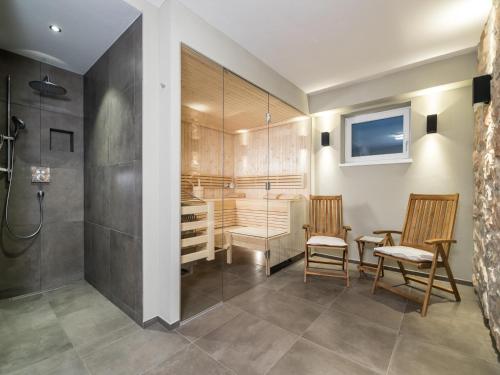 a bathroom with a shower and a table and chairs at Chalet Schneelöwe XL in Leogang