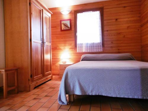 Ce lit se trouve dans une chambre en bois dotée d'une fenêtre. dans l'établissement Les genets, à Brocas
