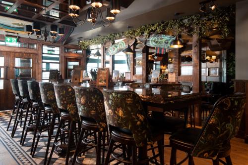 a bar with a long table and chairs at The Tynemouth Castle Inn - The Inn Collection Group in Tynemouth