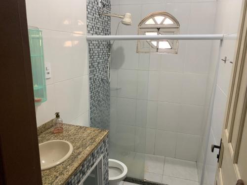 uma casa de banho com um chuveiro, um WC e um lavatório. em Apto Florescer - No Espaço Florescer em Campos dos Goytacazes