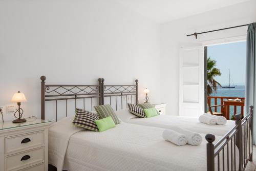 two beds in a bedroom with a view of the ocean at Hotel Efrosini in Platis Gialos