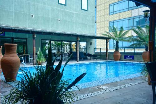 a swimming pool in front of a building at Harbour View Suites in Dar es Salaam