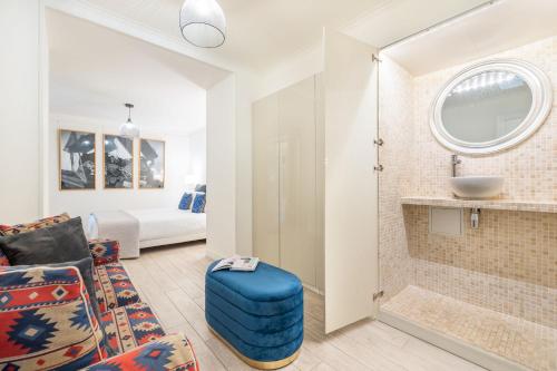 a living room with a blue ottoman and a bathroom at Duran Duran in Paris