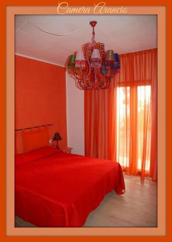 a red bedroom with a red bed and a chandelier at La Rosa dei Venti Resort in Piombino