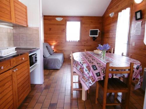 eine Küche mit einem Tisch mit Stühlen und einem Sofa in der Unterkunft La bardane in Brocas