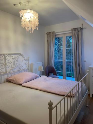 a bedroom with a large bed and a chandelier at Casa Anna in Villach