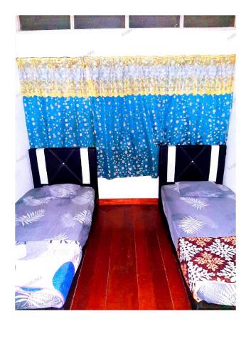 dos camas sentadas una al lado de la otra en una habitación en AABM DELIMA HOMESTAY en Ipoh