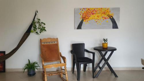 a table and chairs in a room with a tree on the wall at Habitación en apartamento compartido en Envigado in Envigado