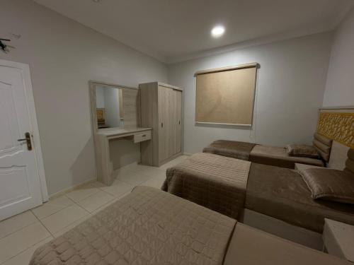 a hotel room with two beds and a mirror at شقه راقيه سويت قريبه من المسجد النبوي تتسع لاربع اشخاص in Al Madinah