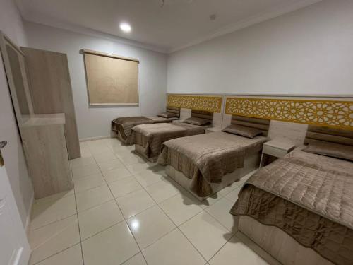 a room with four beds and a painting on the wall at شقه راقيه سويت قريبه من المسجد النبوي تتسع لاربع اشخاص in Al Madinah