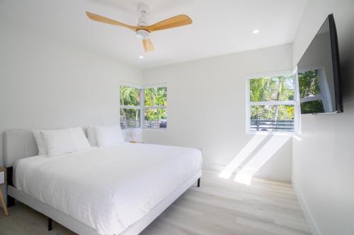 a white bedroom with a bed and a ceiling fan at Havana House Miami in Miami