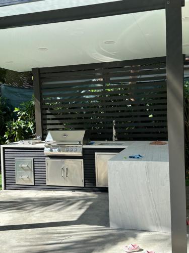 an outdoor kitchen with a stove and a grill at Havana House Miami in Miami