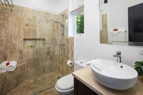 a bathroom with a sink and a toilet and a shower at Playa Laguna Vacation Condos in Sosúa