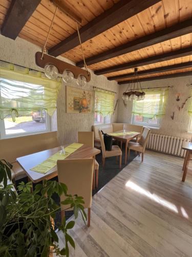 un restaurante con mesas, sillas y ventanas en Pension 3 Ferienhof Hanstorf, en Satow