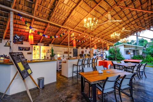 a restaurant with tables and chairs and a bar at Hotel Enjoy in Las Terrenas