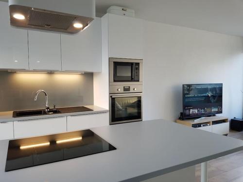 a white kitchen with a sink and a stove at Studio Nähe Flughafen-Messe Stuttgart in Filderstadt
