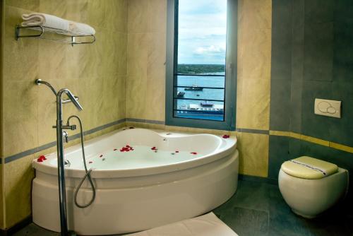 bagno con vasca e finestra di Harbour View Suites a Dar es Salaam