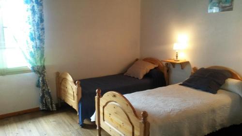 two beds in a small room with a window at Bourdiscat in Campagne