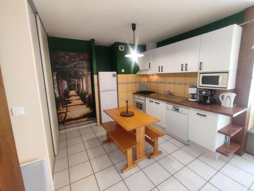une petite cuisine avec une table en bois. dans l'établissement Gîte rural le Rouchassier, à Saint-Laurent-du-Cros