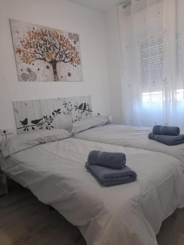 2 Betten in einem weißen Zimmer mit Handtüchern darauf in der Unterkunft Paisaje Príncipe in Alcantarilla
